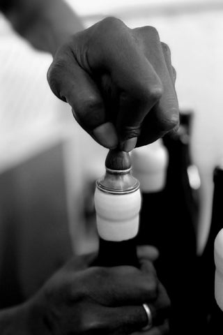 Uncorking a wine bottle, black and white, hand uncorking with corkscrew