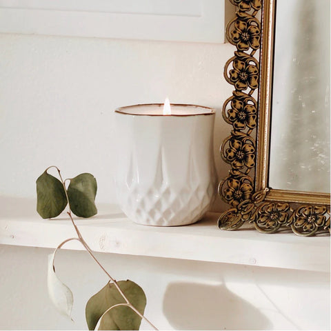 Image of Hyggelight candle lit, sitting on a mantle 