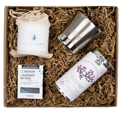 Image of a sustainable gift box that includes a candle from Hive to Home, a canister of rea from Flying Bird Botanicals, hand soap from Soap Distillery and a to-go mug from Klean Kanteen