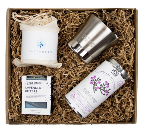 Image of a sustainable gift box that includes a candle from Hive to Home, a to-go mug from Klean Kanteen, tea from Flying Bird Botanicals and hand soap from Soap Distillery