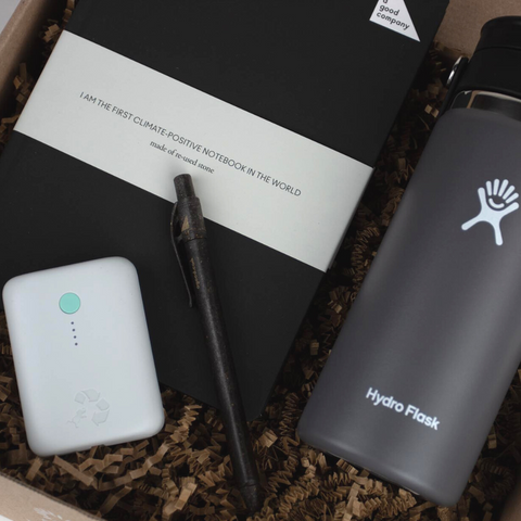 Image of gift box filled with sustainable gifts like a stone notebook, a Hydroflask Coffee Mug, and more