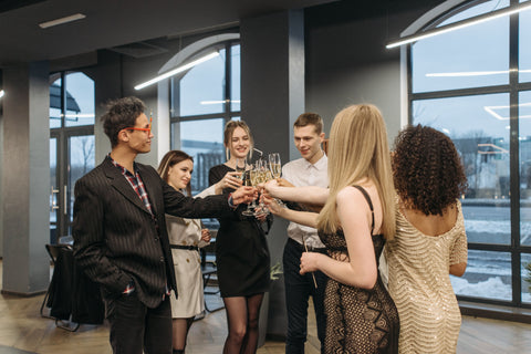 Image of a group of people cheersing glasses of champaign in an office setting