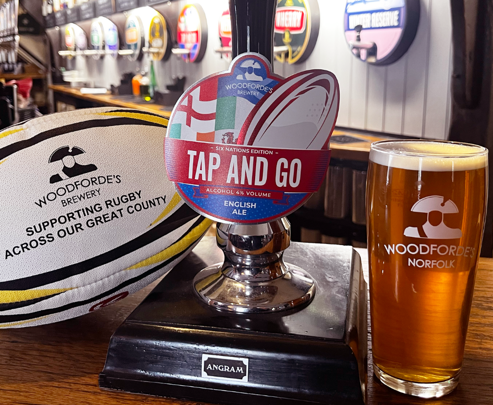 Woodforde's Tap and Go pint with pump and rugby ball