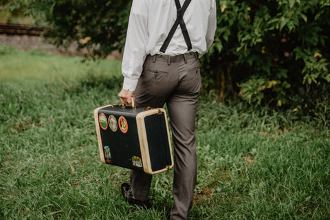 homme qui tient une vieille valise