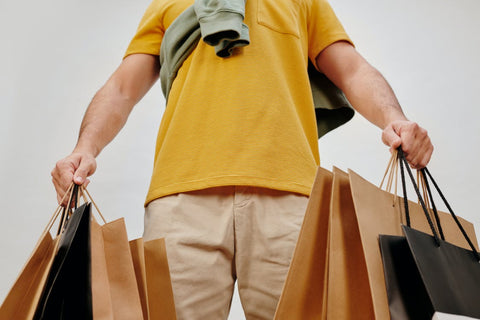 un homme qui tient des sacs de shopping dot-drops