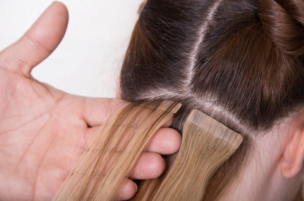 tape-in hair extensions being installed