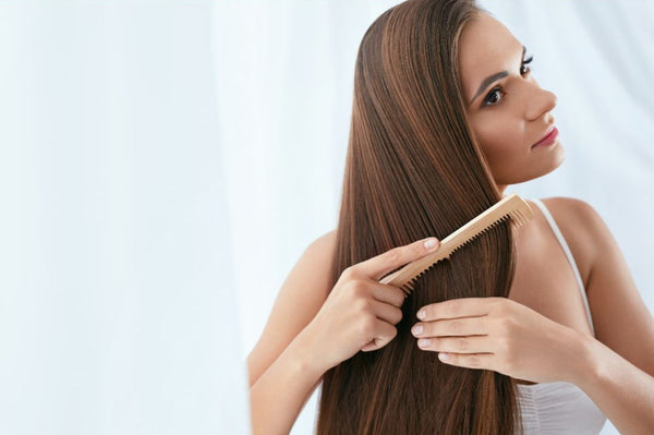 mujer cepillando extensiones de cabello