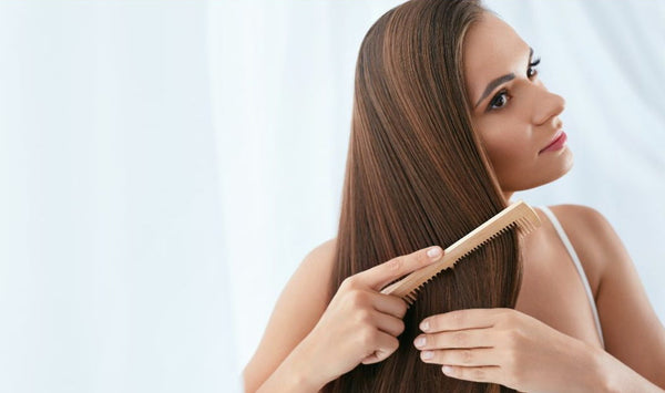 Mujer cepillando extensiones de cabello en Málaga