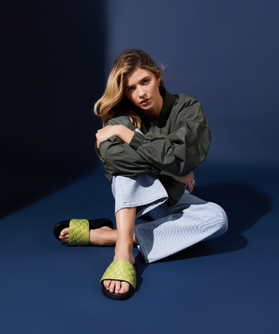 model wearing casual outfit and green womans slides