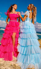 Image of a pink ruffled ball gown and a blue ruffled ball gown being worn by two women standing outside.