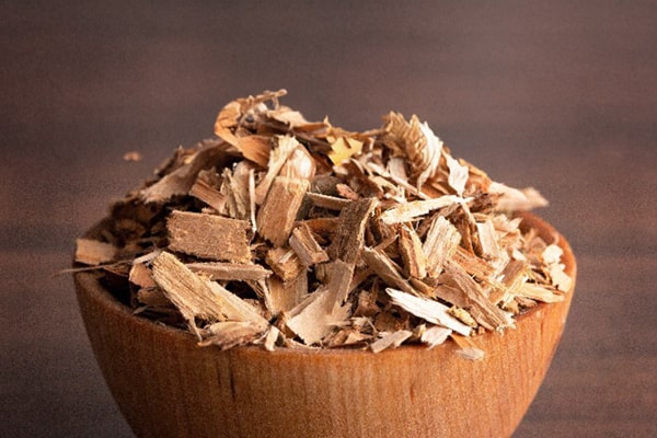 A bowl of white willow bark with a spoon, symbolizing one of the herbal remedies for pain relief discussed in the MDBiowellness- Plant Medicine post '6 Herbal Remedies for Pain Relief: Natural Pain Relievers That Work,' developed by Doctors.