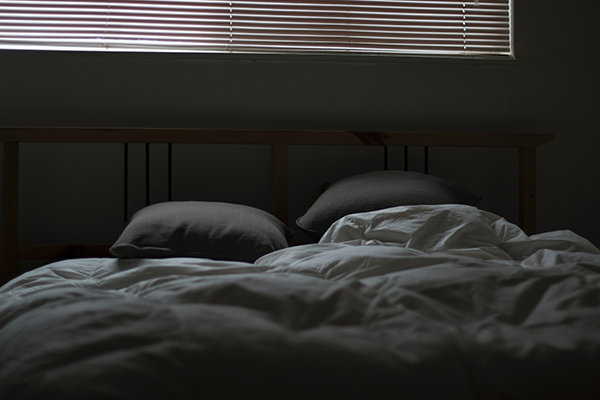 Depicts a person situated in a meticulously arranged bedroom with optimal temperature and reduced noise and light disturbances. This image complements the content of the '15 Ways on How to Calm Anxiety at Night Naturally' post for MDBiowellness- Plant Medicine, a program developed by medical professionals, emphasizing the importance of creating a soothing sleep environment to naturally alleviate nighttime anxiety.