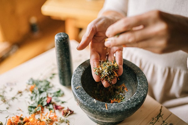 A person preparing a herbal medicine infusion