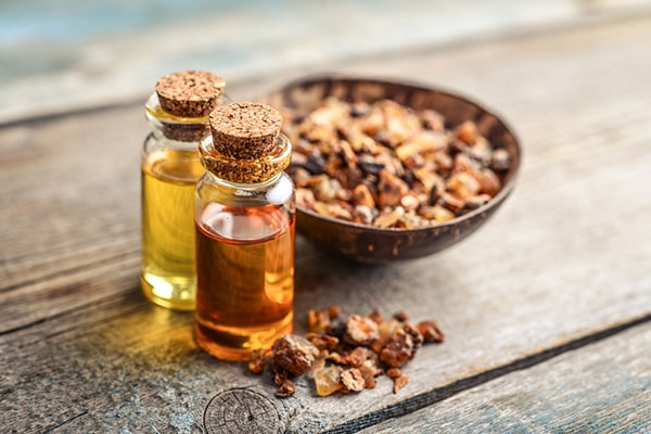 A person using myrrh essential oil in traditional Chinese medicine - Uncover the timeless Myrrh Oil Benefits for 2023 and Beyond in this enlightening post by MDBiowellness- Plant Medicine. Developed by Doctors.