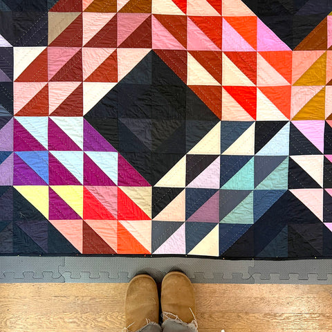 A quilt being blocked with pins.