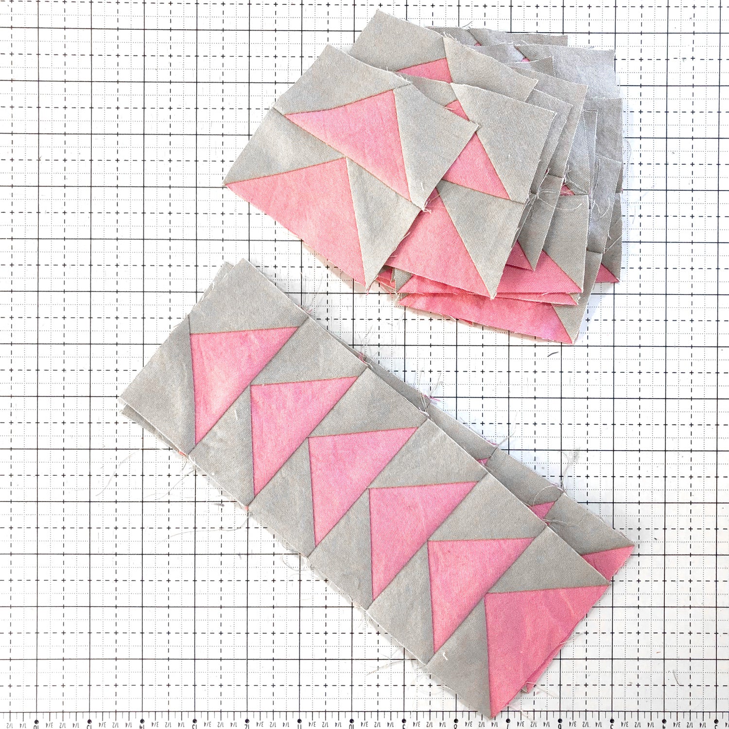 Flying geese blocks made of pink and gray fabrics.