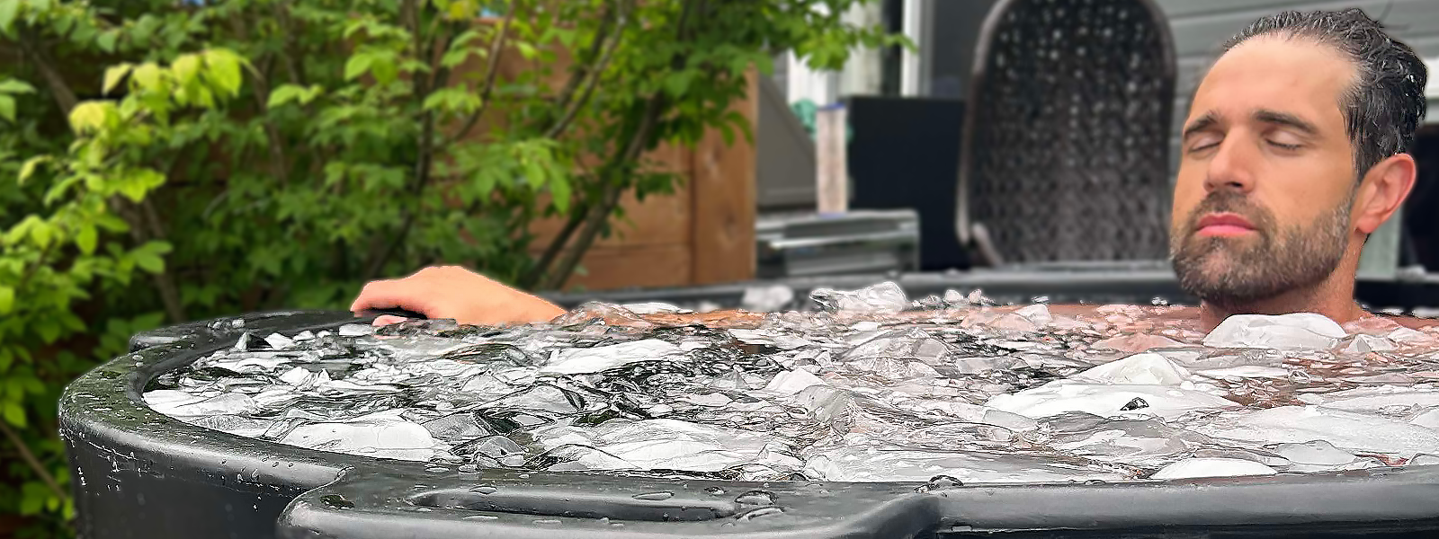 A person taking a cold plunge inside his Eternal Ice HD Pro ice bath, lying down in the tub filled with ice and cold water.