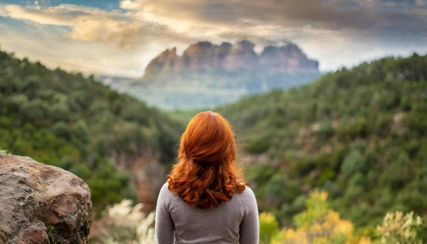 femme de dos face a un paysage naturel évoquant la sérénité et le contrôle de ses pensées face à une crise d'angoisse