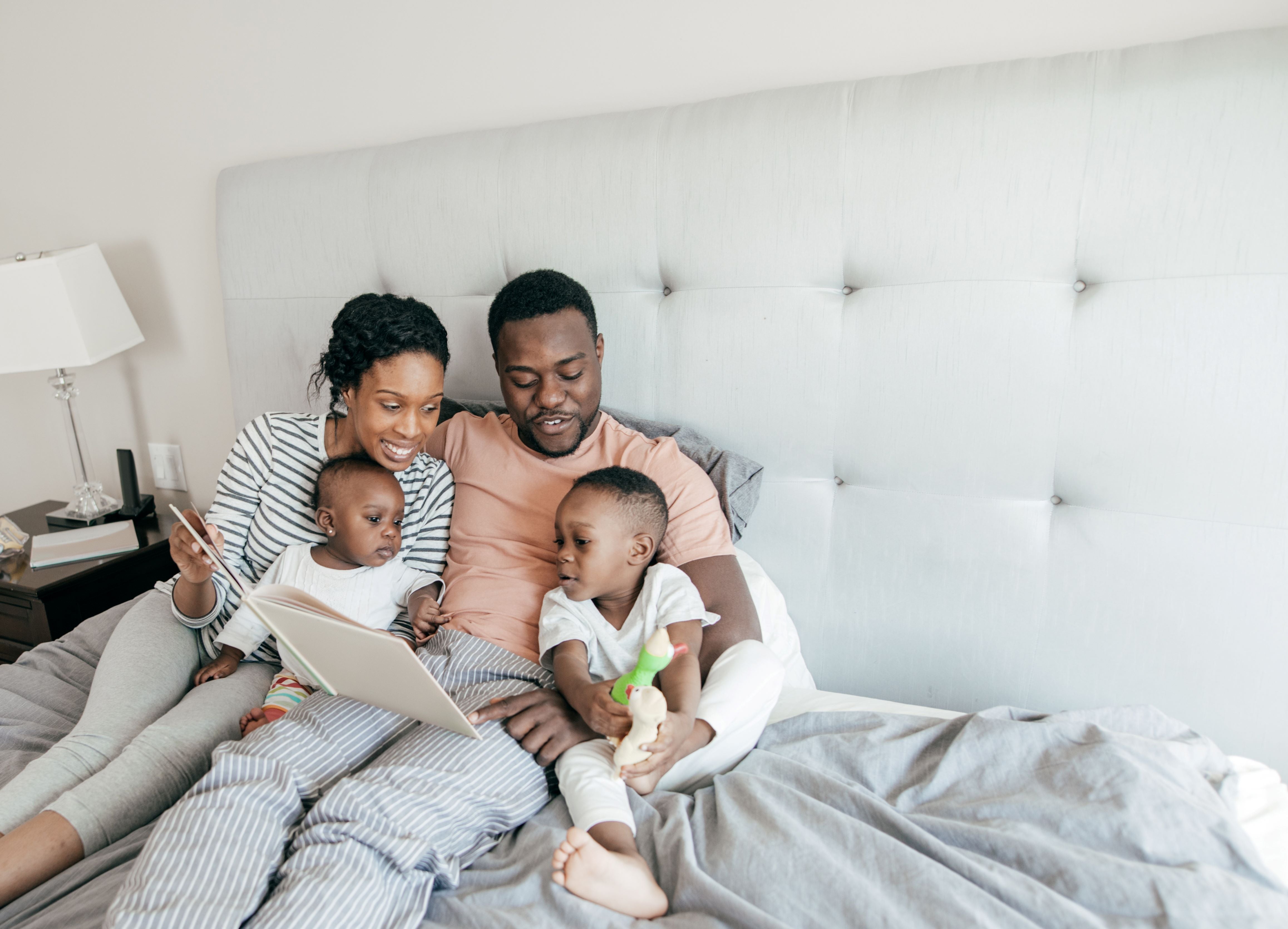 A family in their sleepwear reading a book.