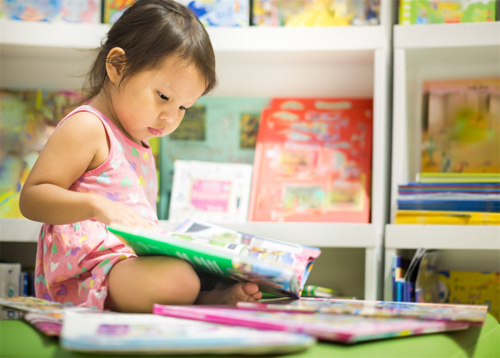 A smart little girl reading books in the bookstore