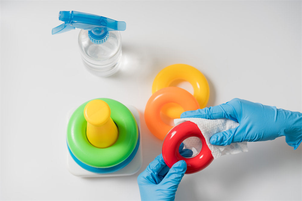 Hands in nitrile gloves are cleaning and disinfecting toys