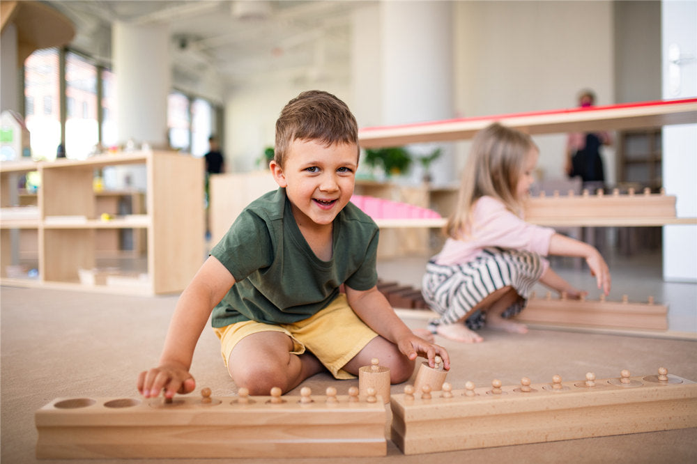 A group of small nursery school children playing indoors in classroom, montessori learning