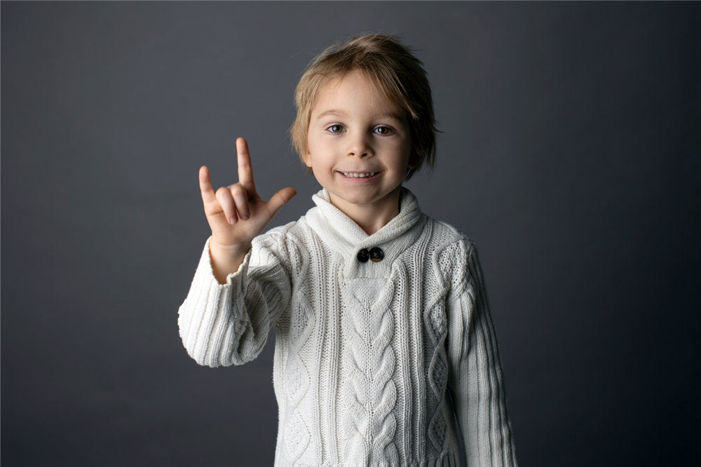 Cute little toddler boy, showing I LOVE YOU gesture in sign language