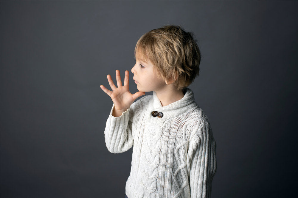 Cute little toddler boy, showing MOTHER gesture in sign language