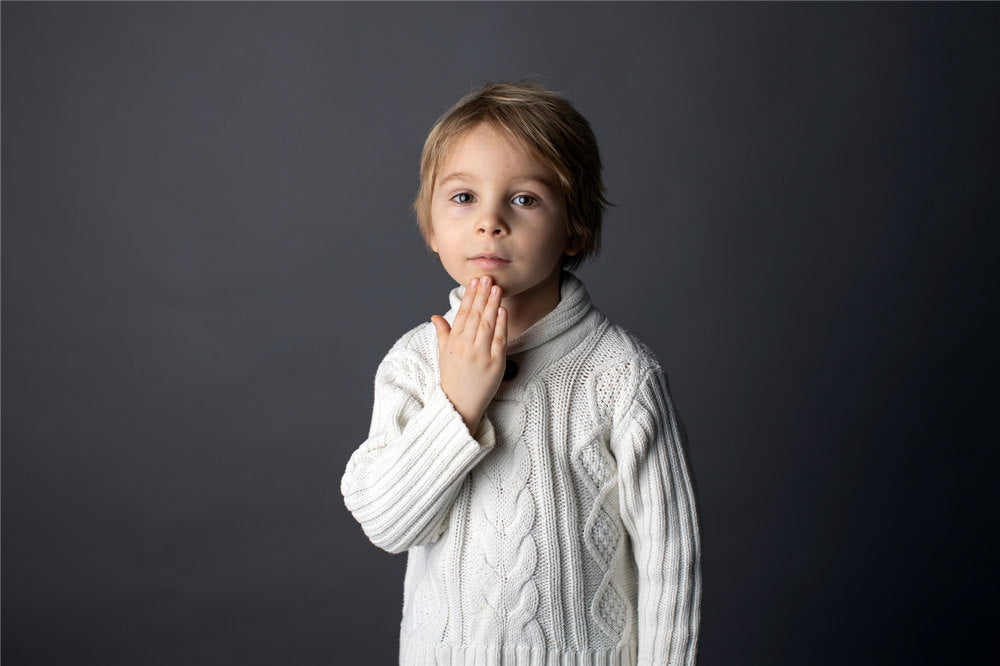 Cute little toddler boy, showing THANK YOU gesture in sign language