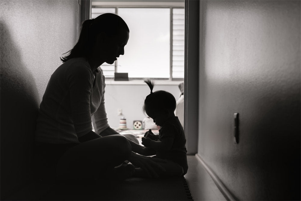 Sad mother at home with baby feeling depressed