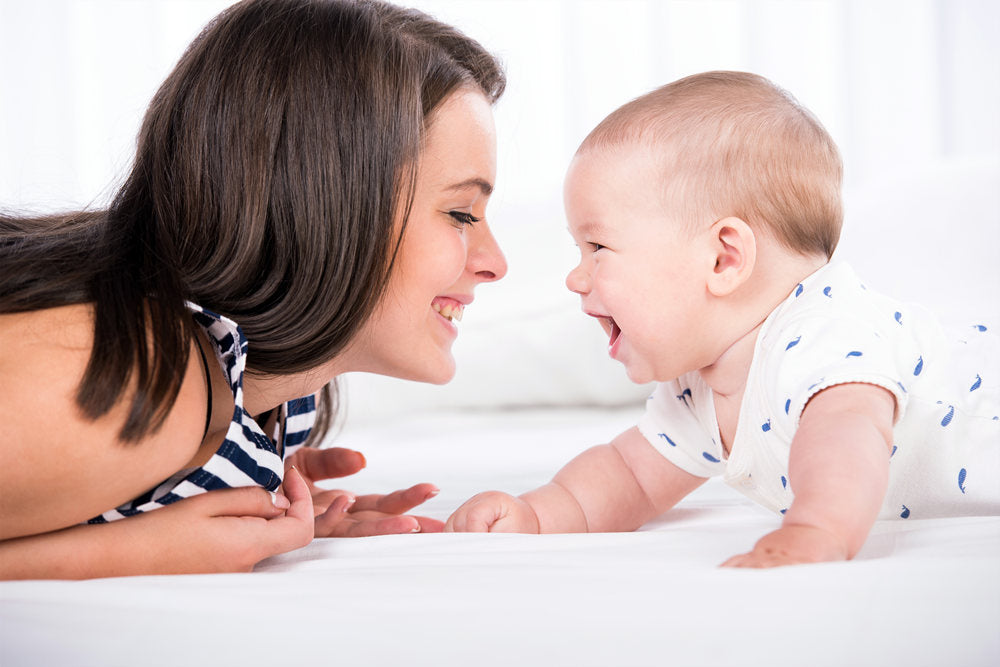 Beautiful mother and son are lying in bed and looking at each other