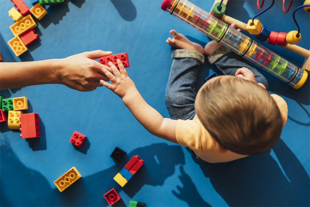 Happy baby playing with toy blocks