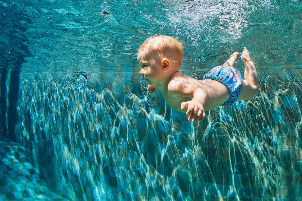 Child jump underwater into swimming pool