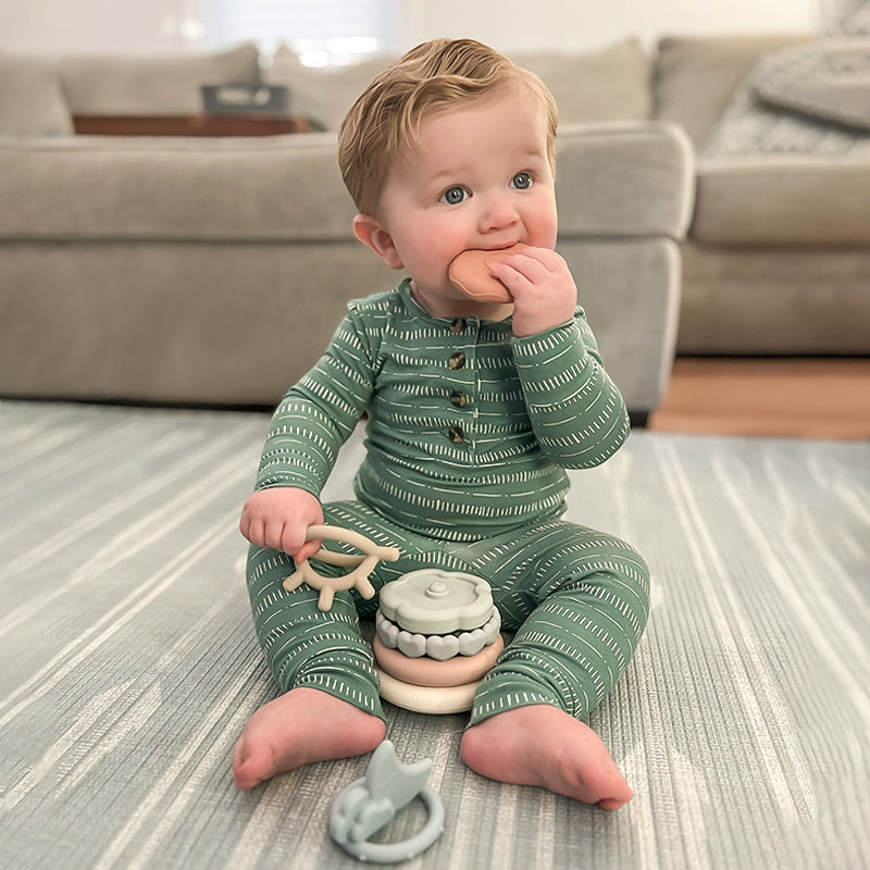 a toddler chewing on a Moonkie teething ring
