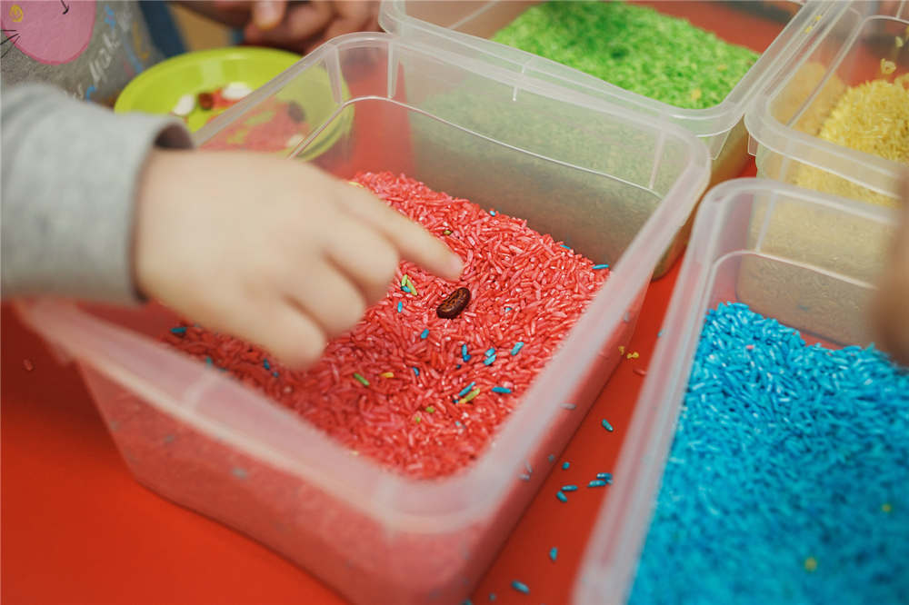 Children play educational games with a sensory bin