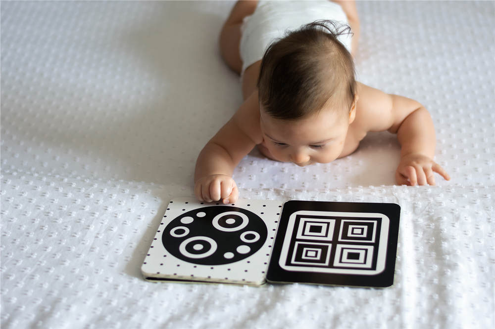 A baby looks at a black and white contrast educational book