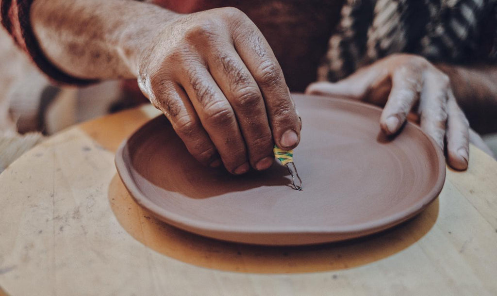 Craftsman Carving a Handmade Pottery Bisque Plate