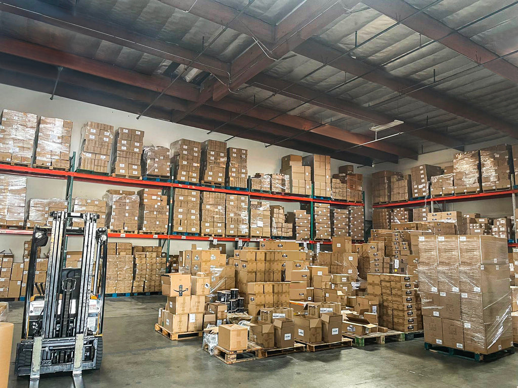 Interior of COLOER's warehouse with neatly stacked boxes and forklift, showcasing efficient order processing and delivery readiness for landscape lighting products.