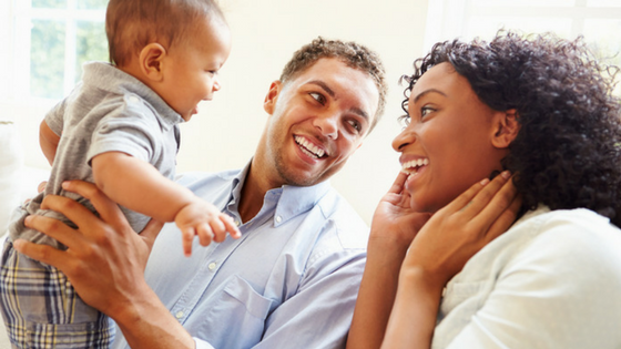 Young parents smile at their happy baby