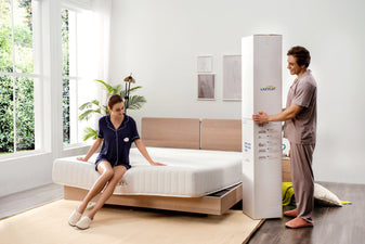 couple is preparing to roll their new bed in a box