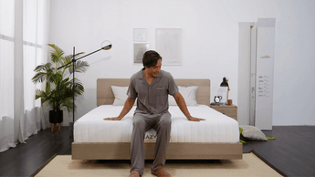 man happily tests out his new mattress