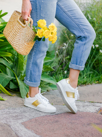 woman wearing Joyasol Paisley sneakers holding yellow flowers