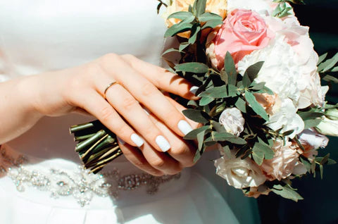 Bride with flowers and wedding nails