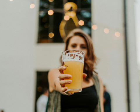 Woman holding beer in front of her face