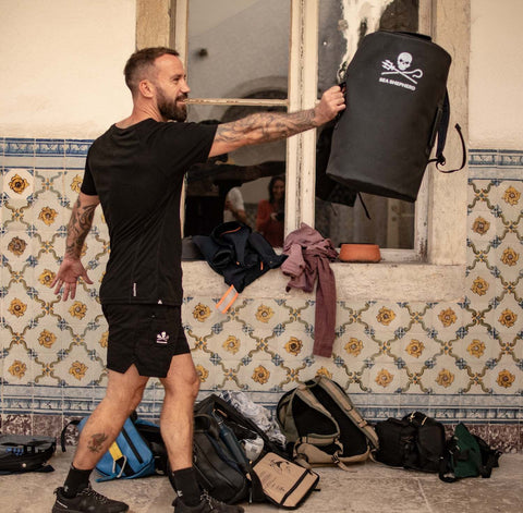 Le sac à dos de voyage 35L en collaboration La Virgule x Sea Shepherd porté par un membre de l'équipage