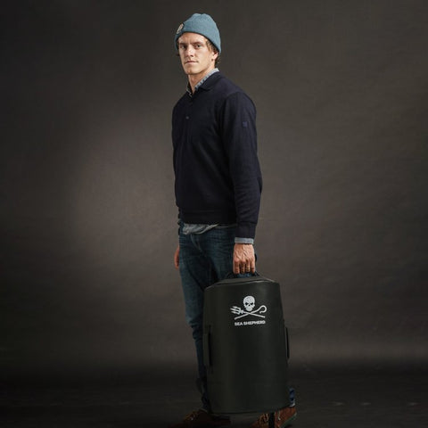 Maxime, co-fondateur de La Virgule, posant avec le sac de voyage 35L La Virgule x Sea Shepherd