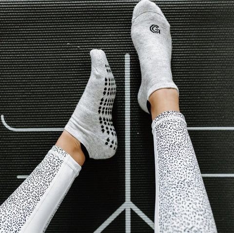 non-slip gripcity grip socks used to stretch out on yoga mat during barre fitness class
