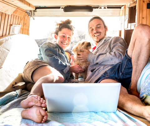 A happy couple living with a dog on the road