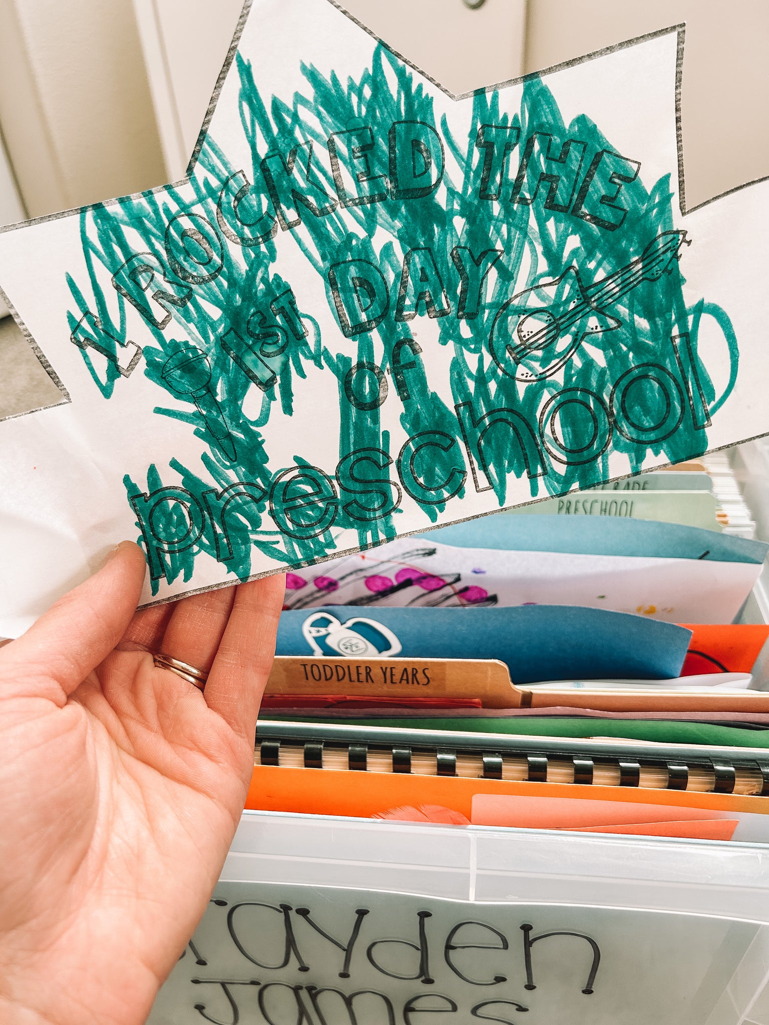 first day of preschool paper crown colored by a child held over the memory tote