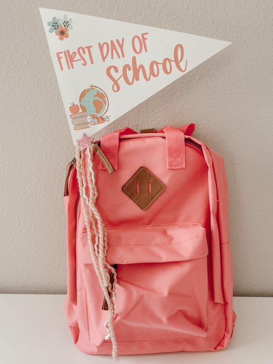 first day of school flag sticking out of a backpack